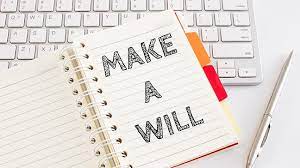 A notebook laying on top of a keyboard is open to a page that says "Make a Will"